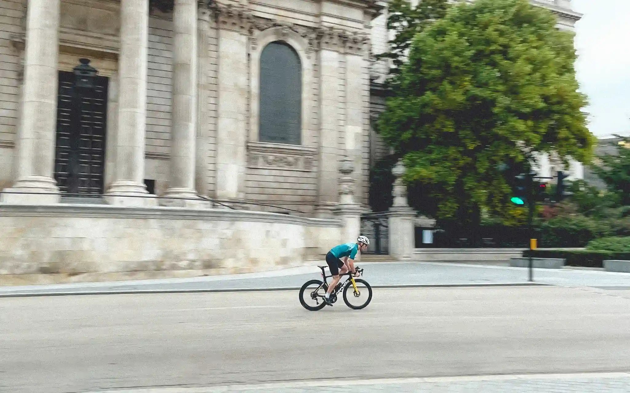 Man cycling on a road next to a cathedral