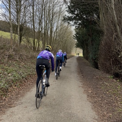 Four UCL riders in club kit on a narrow lane