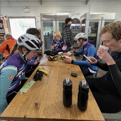 UCL riders in club kit at a cafe stop
