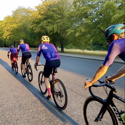 Dawn Raid Velo riders in the pink and purple kit riding through a park