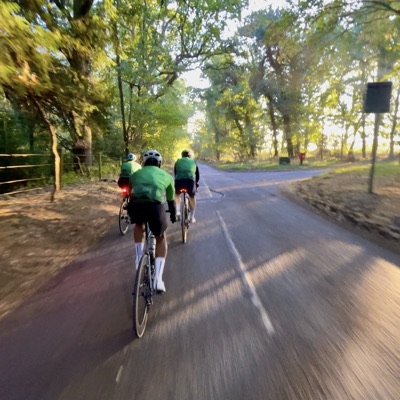 Dawn Raid Velo riders in the green kit on a tree-lined lane