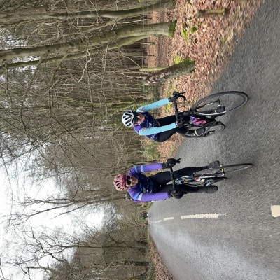 Two UCL riders in club kit on a winter lane