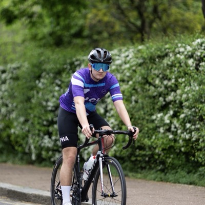 A UCL rider in club kit riding towards the camera